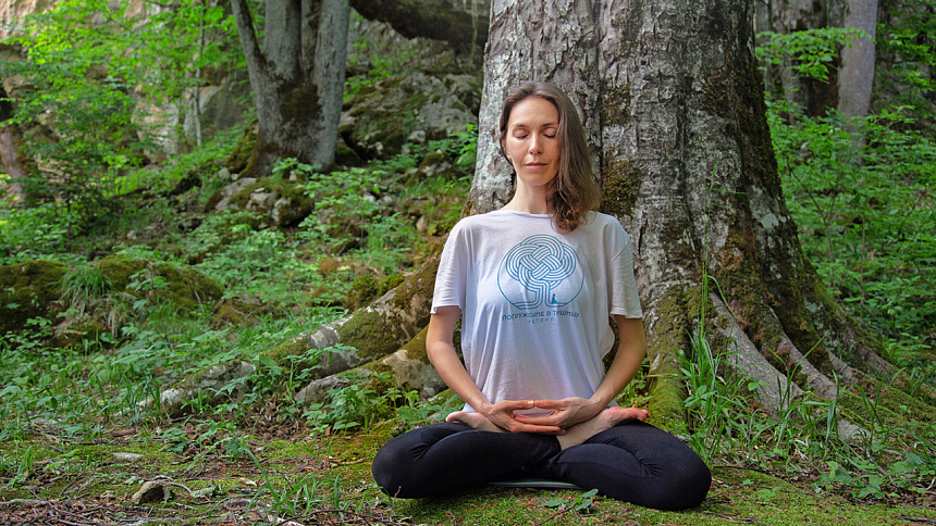 Girl meditating under the tree foto